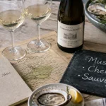Vin blanc de loire sur table : verres, bouteille, huîtres et citron