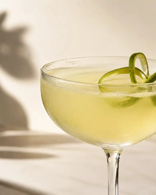 Daïquiri cocktail rhum citron servi dans une coupette froide avec zeste de citron vert