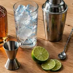 Cocktail benedictine : bouteille ambrée et verre à glaçons, zestes de citron
